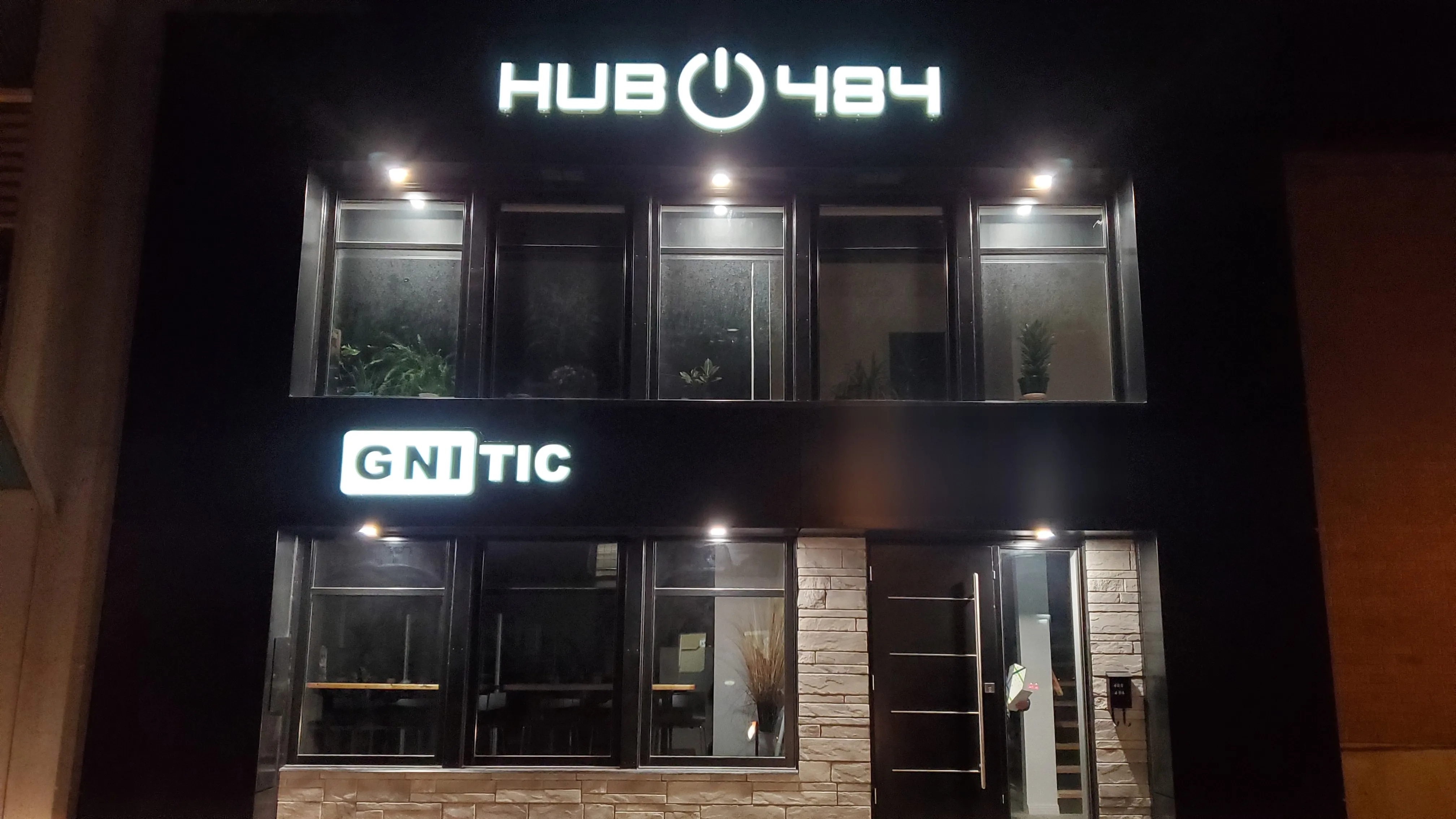 Façade du Hub484 le soir, avec l’enseigne de GNITIC